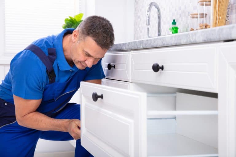 Close-up Of A Male Handyman Installing Door Of Drawer.