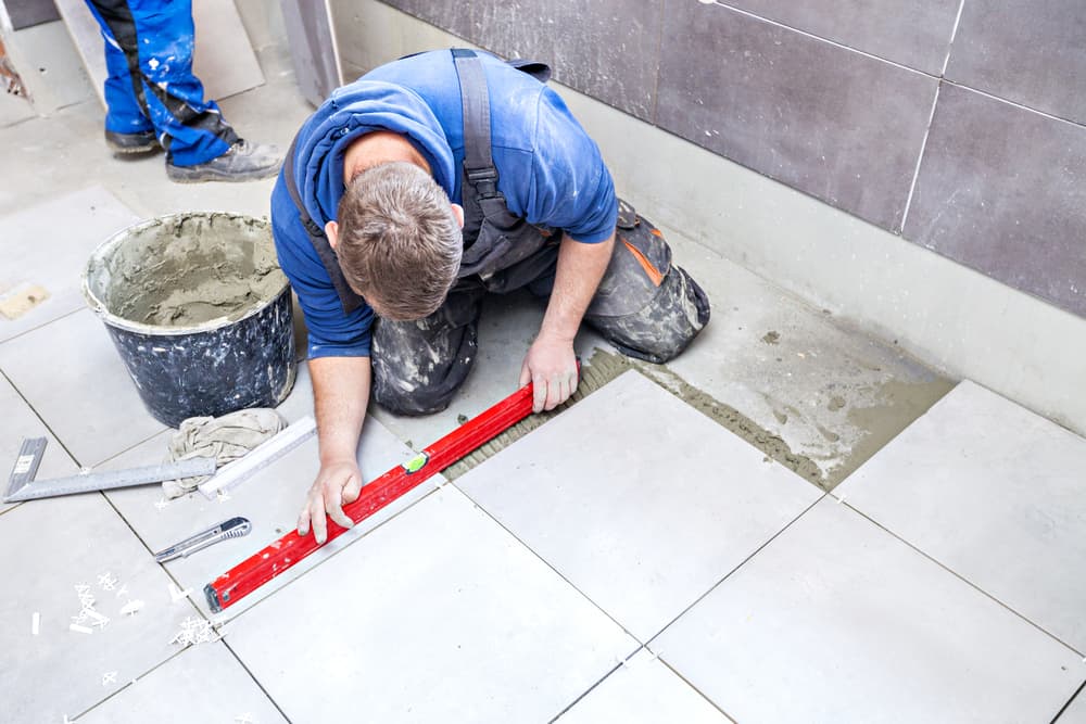 contractor tiling a floor